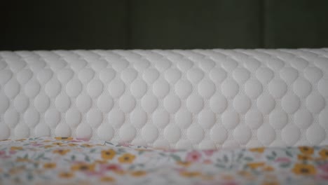 closeup of a white quilted pillow on a bed