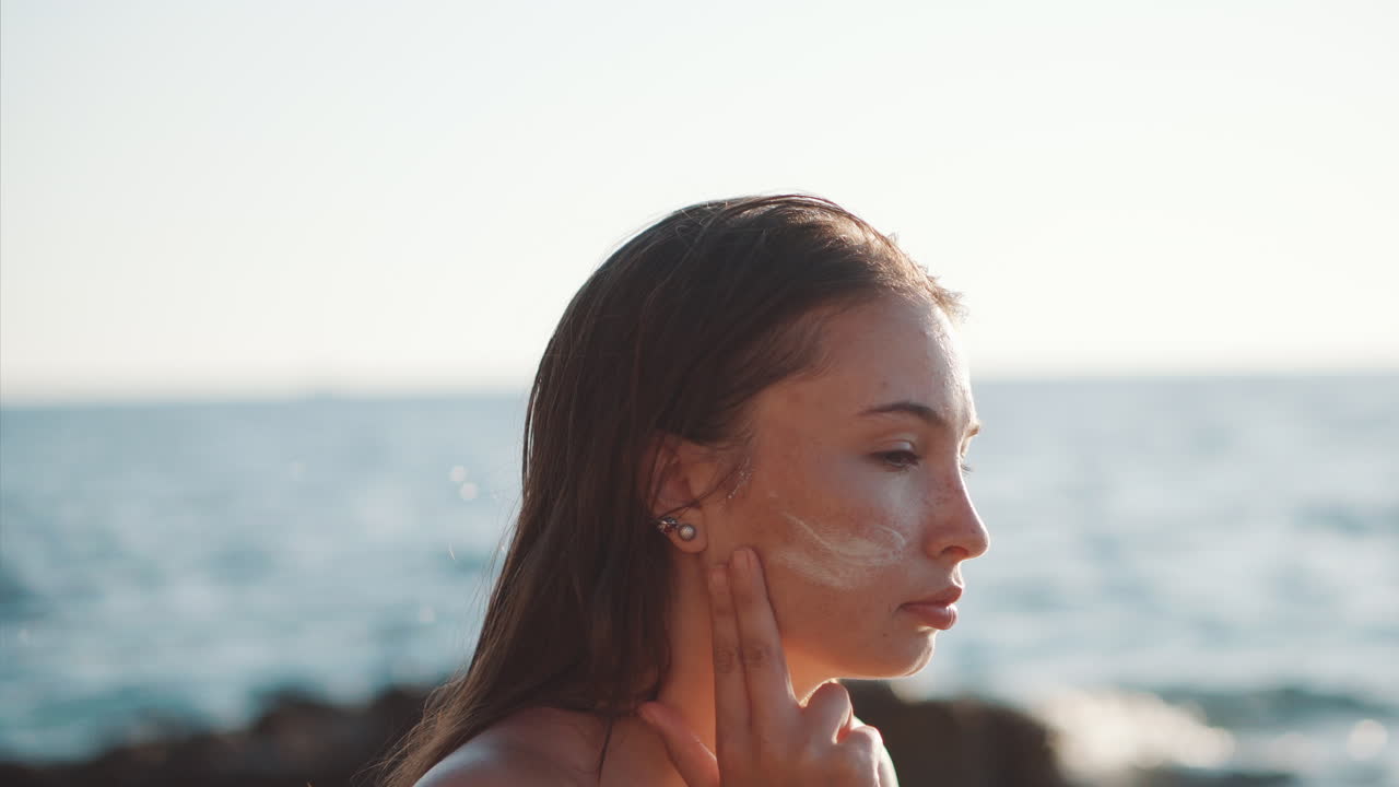 Woman Applying Sunscreen at the Beach