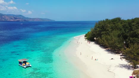 peaceful white beach of tropical island with lush vegetation, anchored boats waiting for tourists visiting best destinations in bali