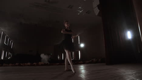 prima ballerina on pointes training on stage with spotlights in late evening before important performance in opera and ballet theatre.