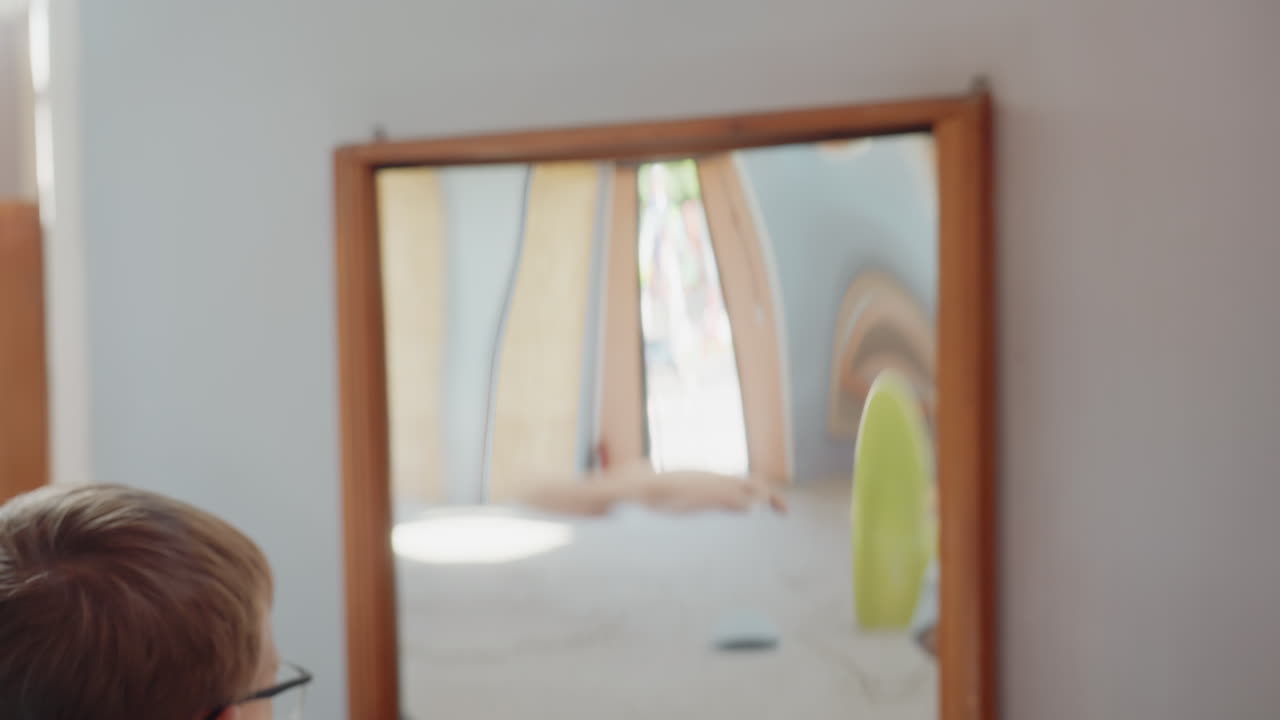 Madre e hijos examinan imágenes en el espejo. La familia se deleita analizando juntos los reflejos ondulados. Toda la familia se dedica a descubrir formas divertidas e inusuales reflejadas en un espejo curvo.
