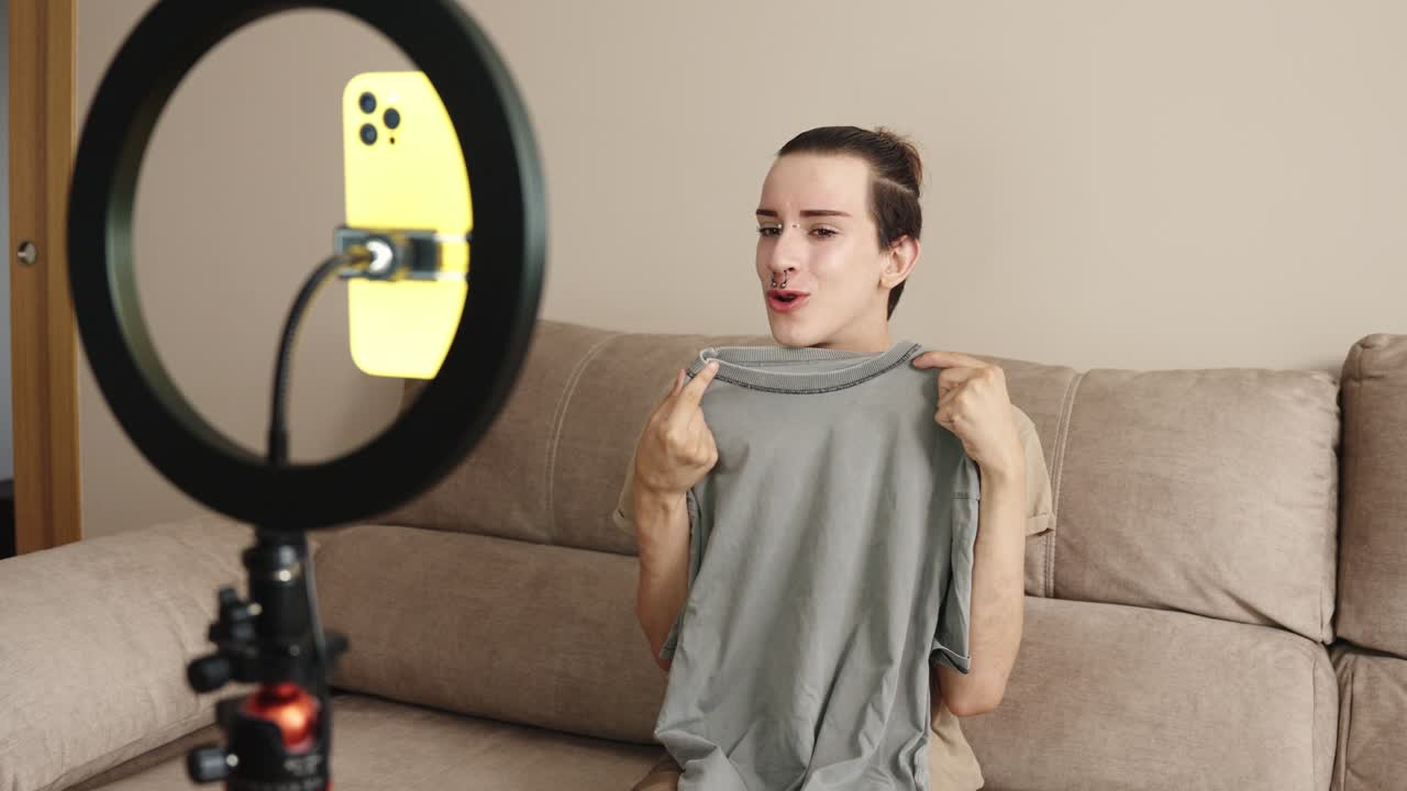 Person showing a t-shirt in front of a ring light