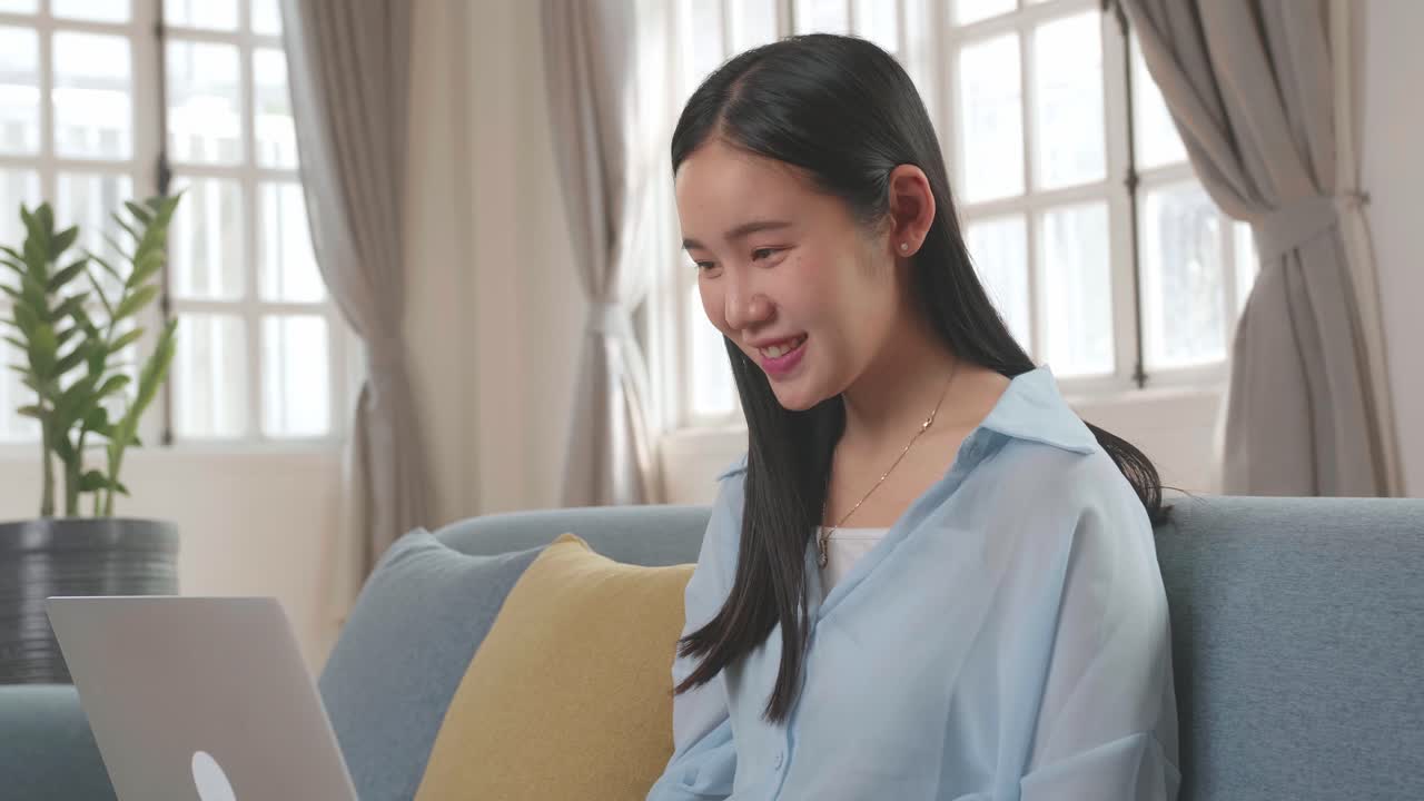 Female Using Laptop And Smiling In Living Room, Video In 4K