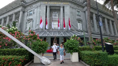 people posing and walking by a grand building.