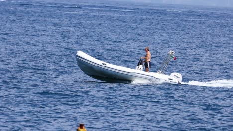 man driving speedboat on calm sea