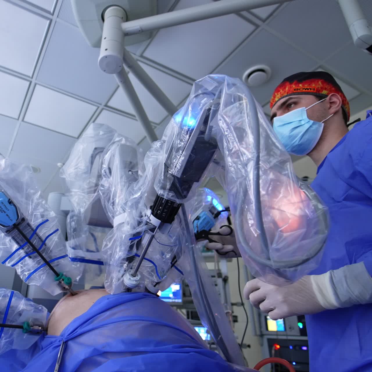Advanced robotic surgery system performing minimally invasive operation. Focused male doctor holding the tool and looking at the screen