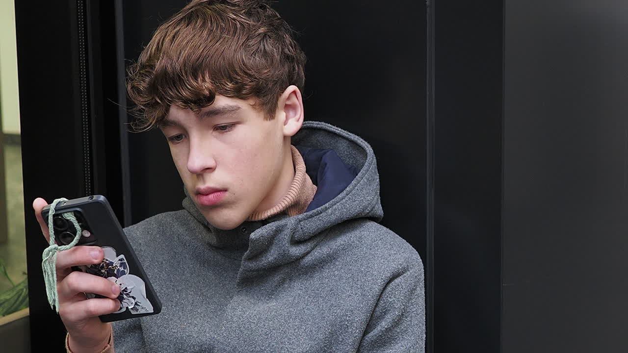 Teenage boy looking at his smartphone