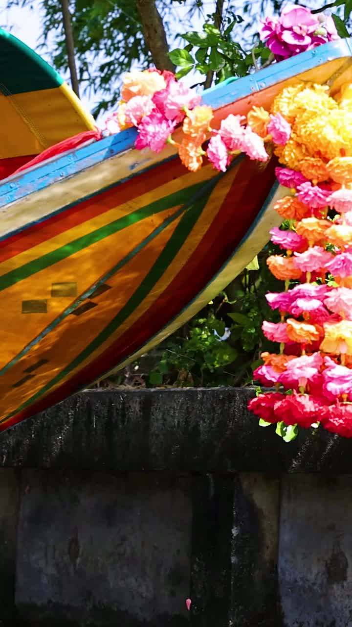 Barca colorata che naviga nel mercato galleggiante di Bangkok