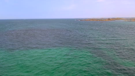 french atlantic near brest, brittany, with a rocky coastline in the distance and vibrant blue-green waters. this seascape highlights the rugged beauty of the region. drone aerial