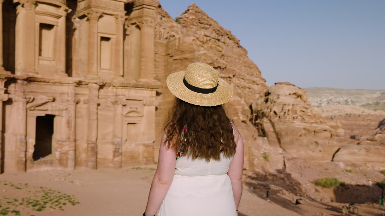 turista femenina en el monasterio de ad deir en petra jordania durante la puesta de sol - de cerca