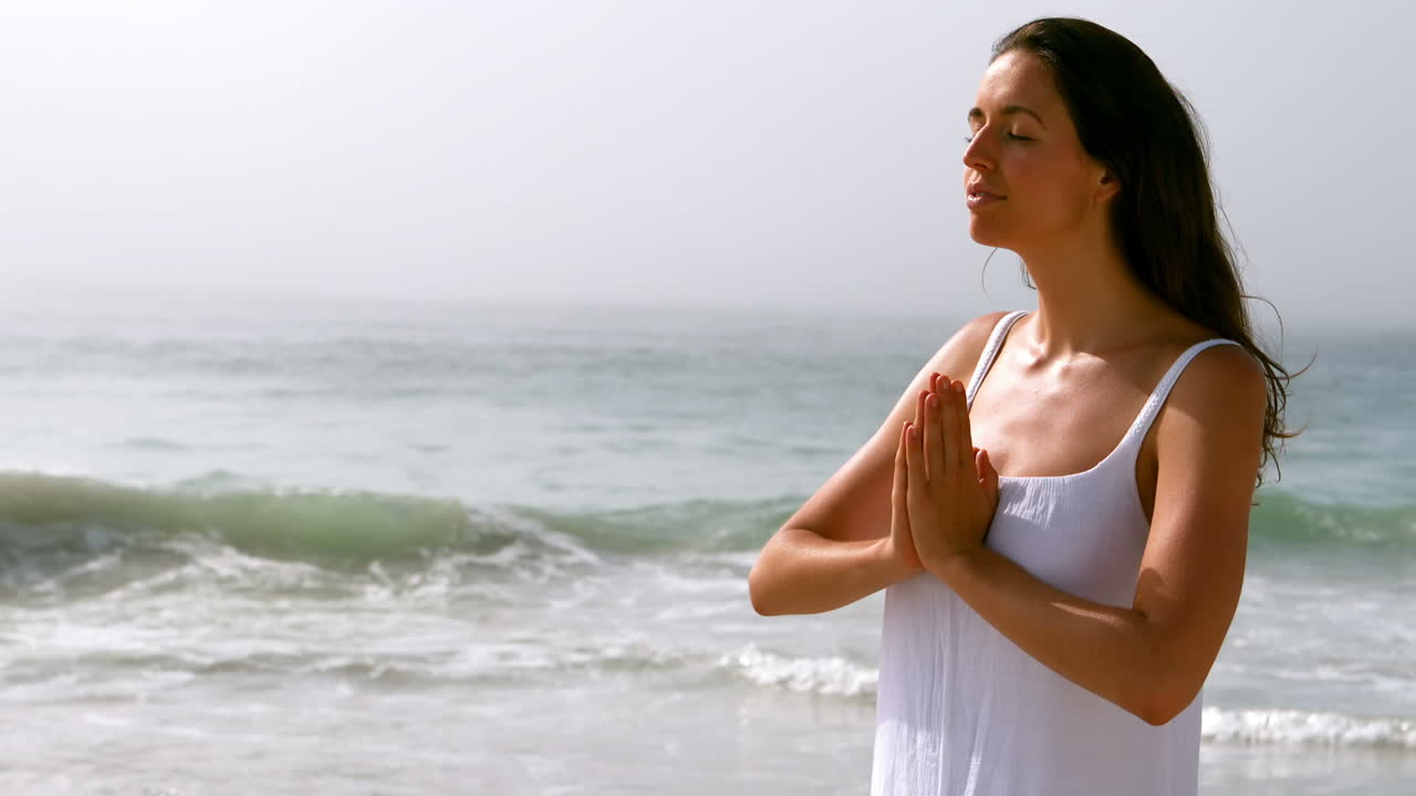 Mujer haciendo yoga en la playa