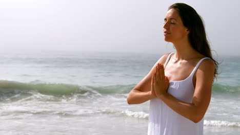 mujer haciendo yoga en la playa