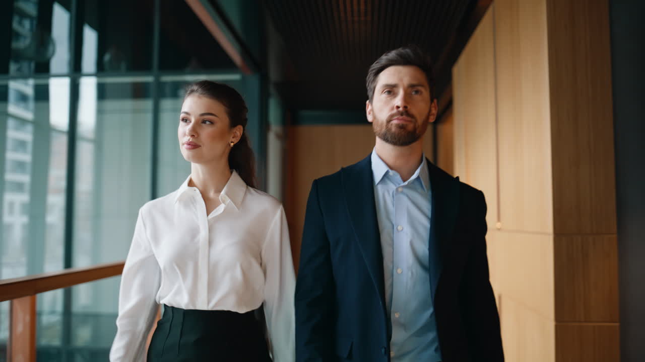 Successful partners walking office hallway together closeup. Confident man woman