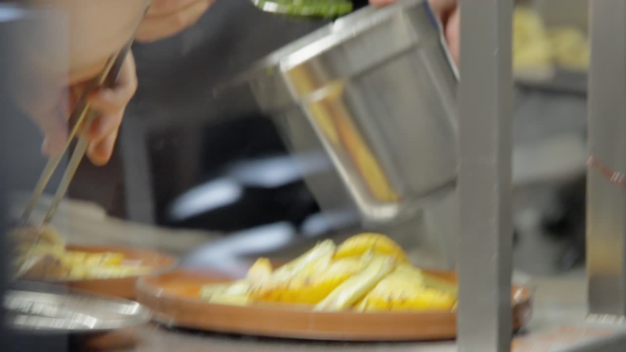 tiro de fritters de quince crujientes en rodajas fritos en un plato con salsa verde vertida desde arriba por los chefs en la cocina de un restaurante