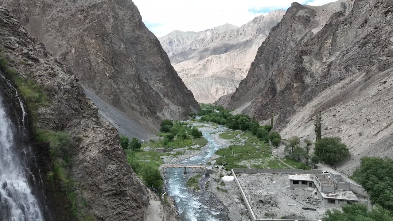 Reveal shot of drone flying close to waterfall and cliff near Mantoka Skardu in Pakistan