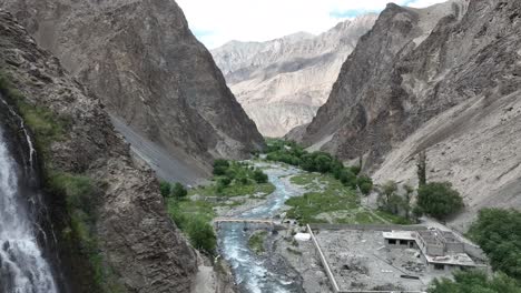 reveal shot of drone flying close to waterfall and cliff near mantoka skardu in pakistan