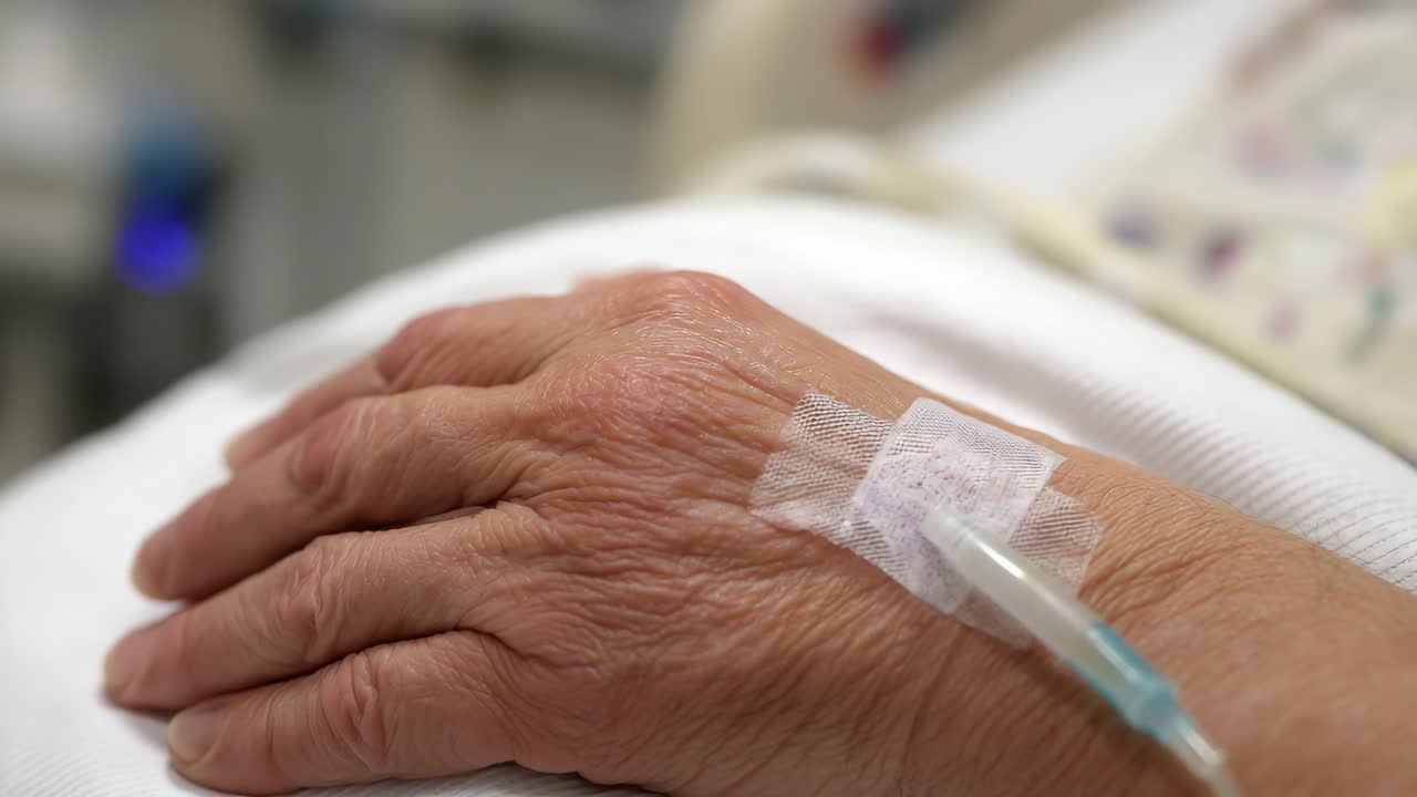 Elderly hand with medical IV drip