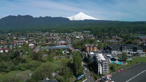 orbiting shot of pucon’s coastline and city center with the iconic villarrica volcano in the background