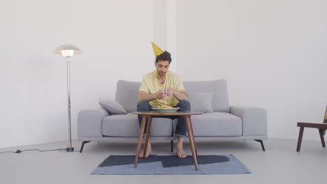 외로운 남자가 생일 케이크 앞에 앉아 있다