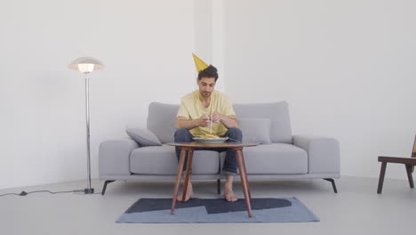 a lonlely man sits in fornt of a birthday cake