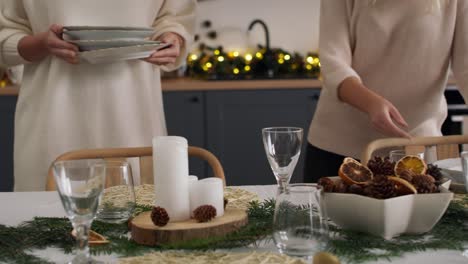 familia preparando la mesa de comedor para la víspera de navidad