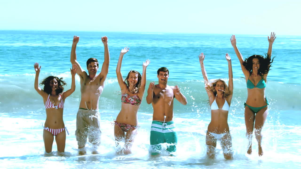 Amici felici che saltano in acqua