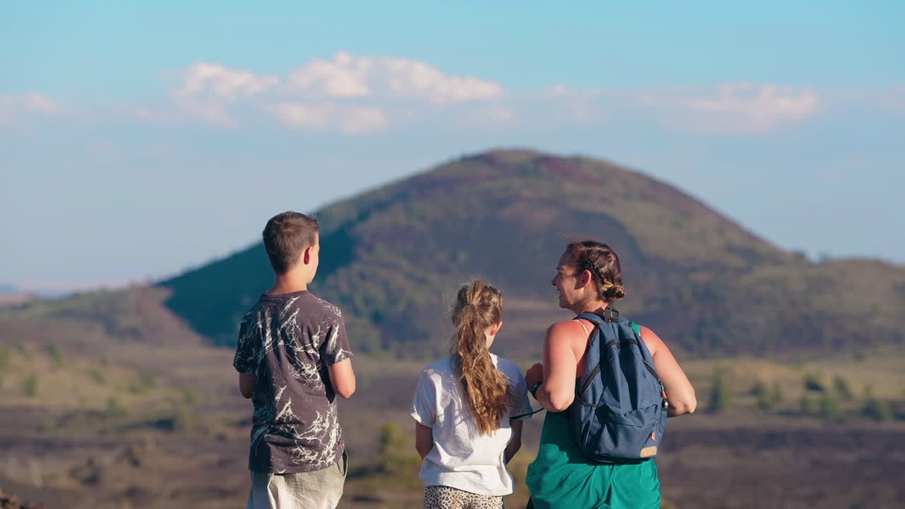 A family gazes at a distant mountain or volcano during an outdoor adventure