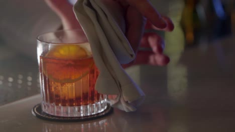 cocktail maker cleans an illuminated cocktail glass