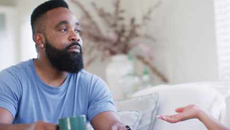 diverse male and female friends talking and having tea at home in slow motion