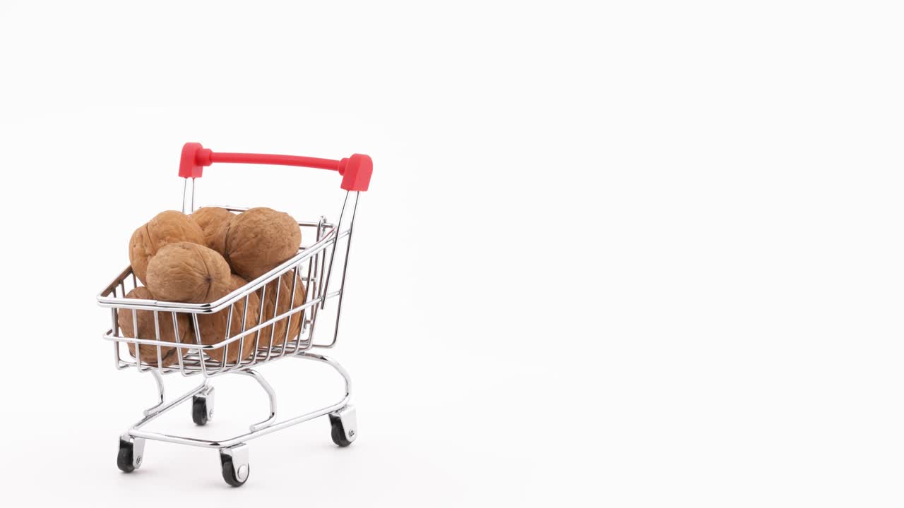 반 프레임: 흑색 바탕에 고립 된 회전 테이블에서 회전하는 견과류로 가득 찬 슈퍼마켓 트롤리의 매크로 촬영.