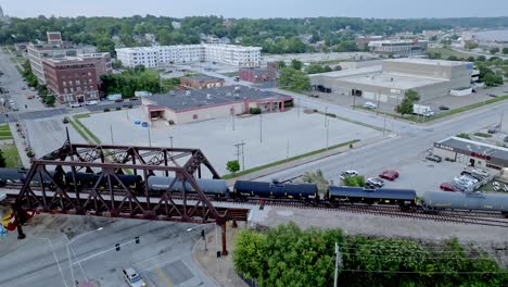 train moving over mississippi river railroad bridge in davenport, iowa with drone video stable