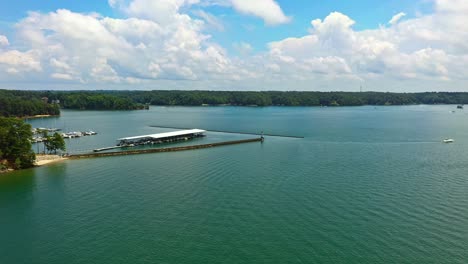 Aerial-flyover-Lake-Lanier-with-jetty-and-marina-port-with-parking-boats-under-roof-in-Georgia