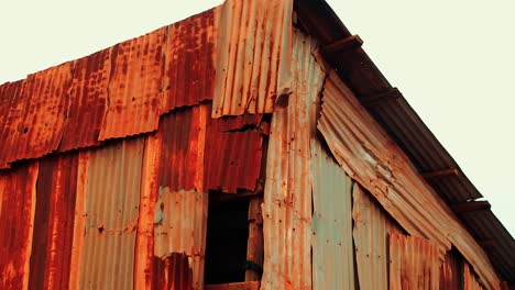 flimsy walls of a shanty tin house being blown away buy the breeze, show the concept of the global crisis of poverty, hunger and wealth inequality
