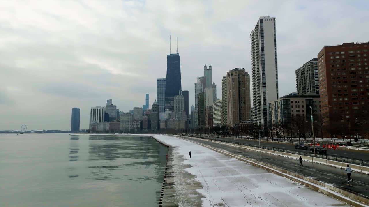 Aerial view following a person walking on the Concrete Beach towards skyscrapers in Streeterville, Chicago, USA