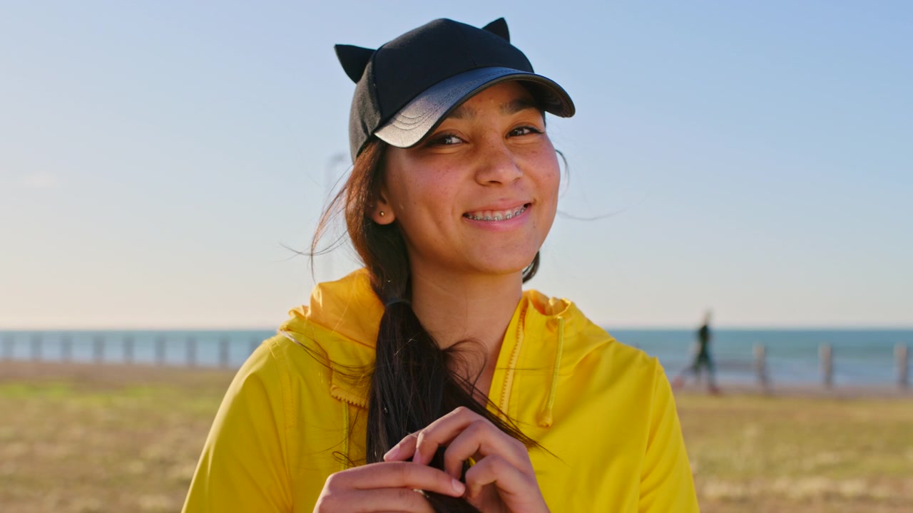 Young Woman in Yellow Hoodie and Cat Ear Cap Smiling Outdoors