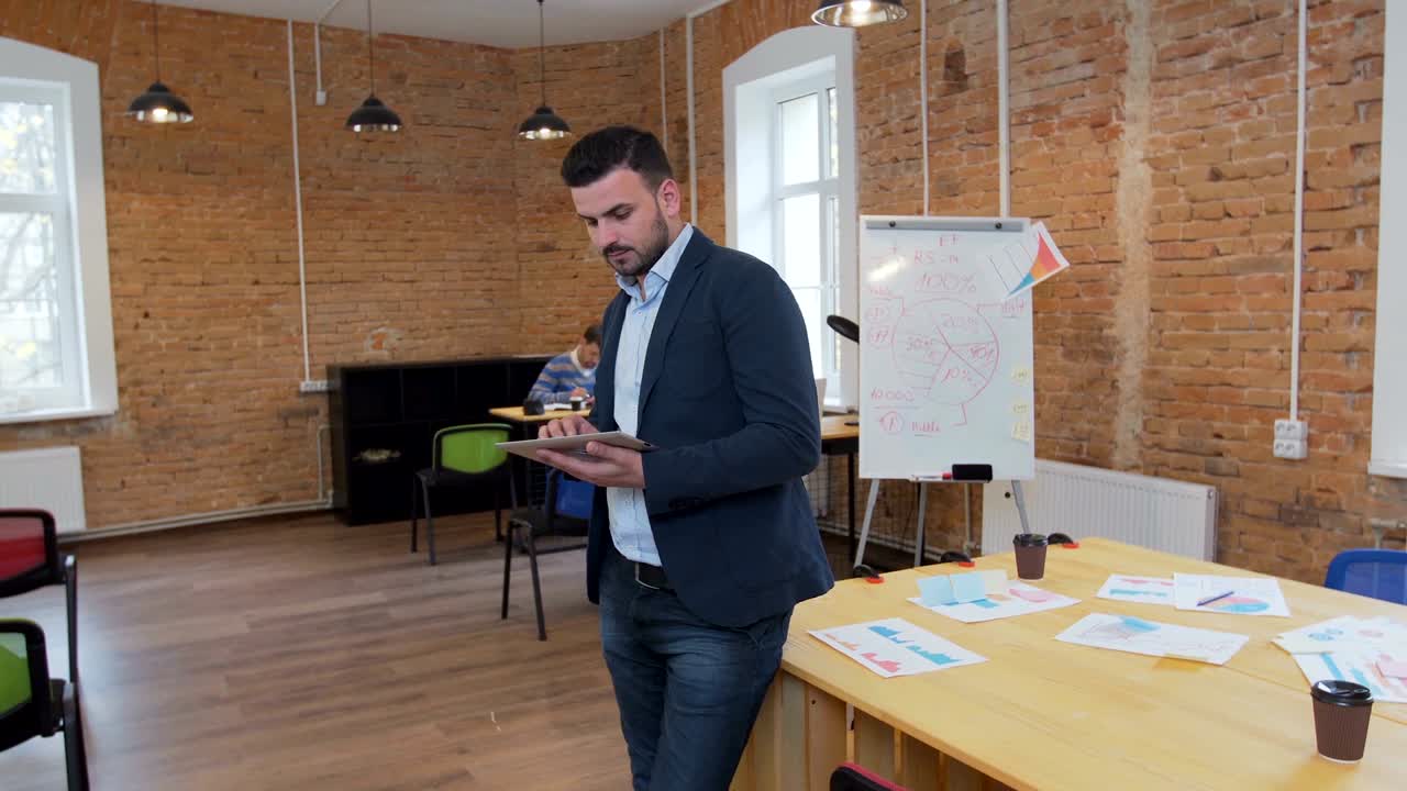 hombre usando una tableta negra con pantalla verde en una oficina moderna. fotografía con estabilizador de cámara.