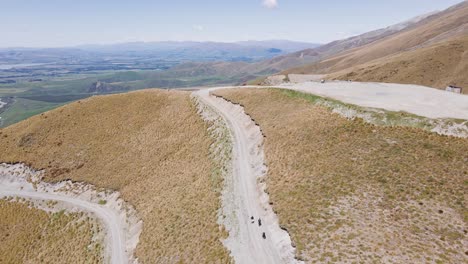 hikers scaling up alpine dirt road in sunny conditions