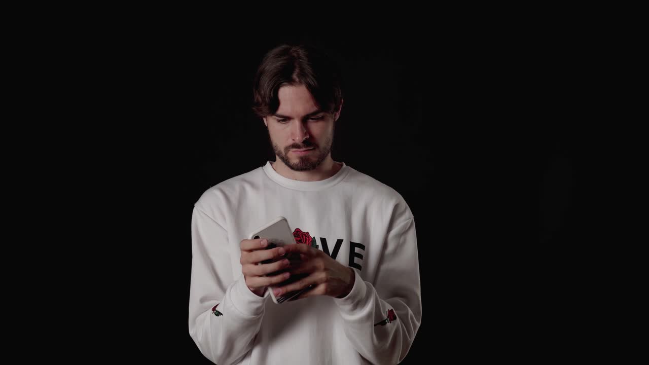 joven de moda usando y escribiendo en el teléfono, amplio fondo negro