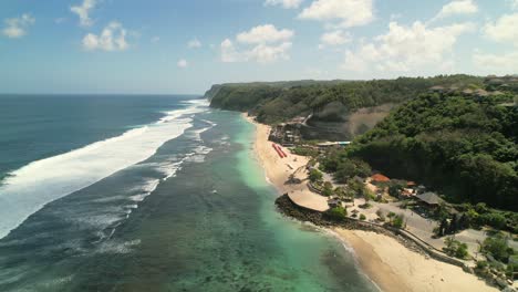 las olas del océano índico rodando sobre la costa de la playa de melasti en uluwatu bali indonesia - vista aérea
