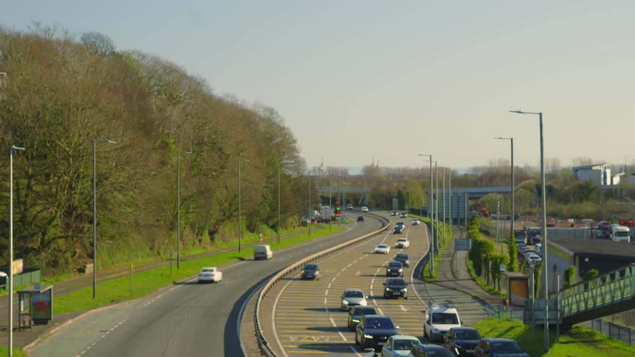 Wide View of Fast Moving Cars and Trucks with Motion Blur on Busy Road Approaching Traffic Lights on Bright Sunny Day. Transport Timelapse Footage.