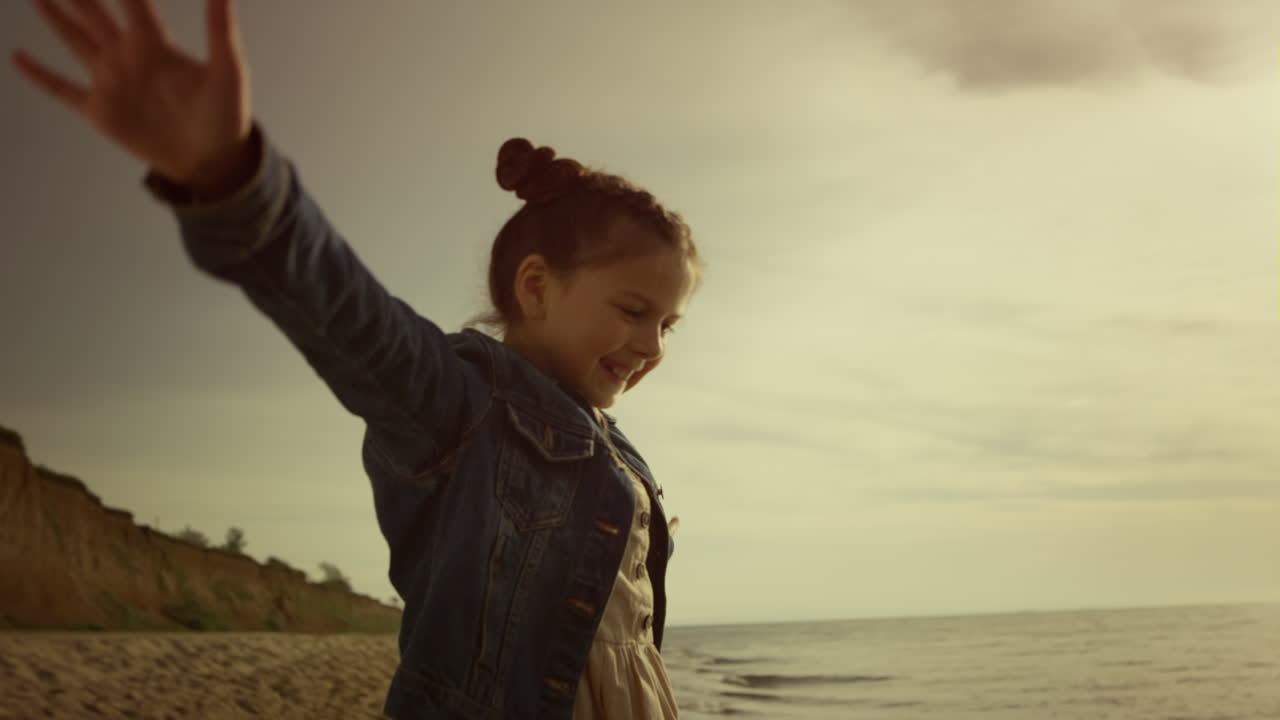 Adorable girl playing sea on morning ocean beach. Cute kid having fun on holiday
