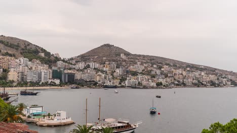 Slow-zoom-in-timelapse-towards-beachside-city-with-tall-buildings-and-boats