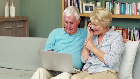 senior couple using laptop and smartphone