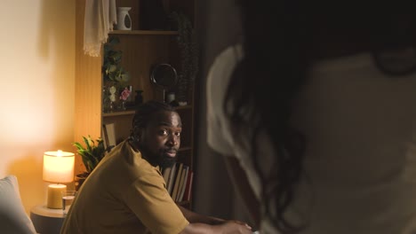 young couple relaxing at home at night talking together