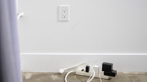 man unplugging the extension cord on wall socket