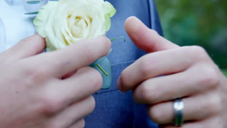 Adjusting-boutonniere,-person-in-suit-standing-against-floral-animation-background