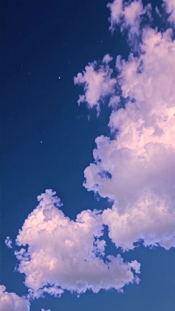 Time lapse di nuvole rosa che si muovono attraverso un cielo notturno blu intenso