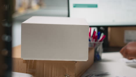 vertical video black woman packing goods and applying shipping labels on boxes