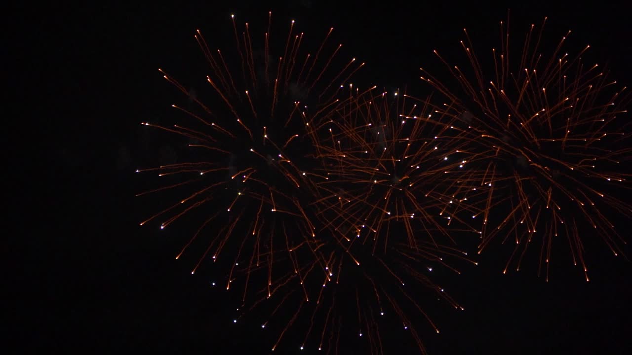 Beautiful slow motion fireworks exploding against dark night sky