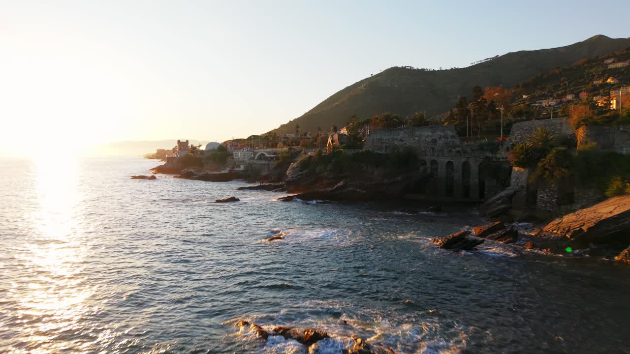 Sunset drone footage of Genoa coastline with clear skies and calm waters